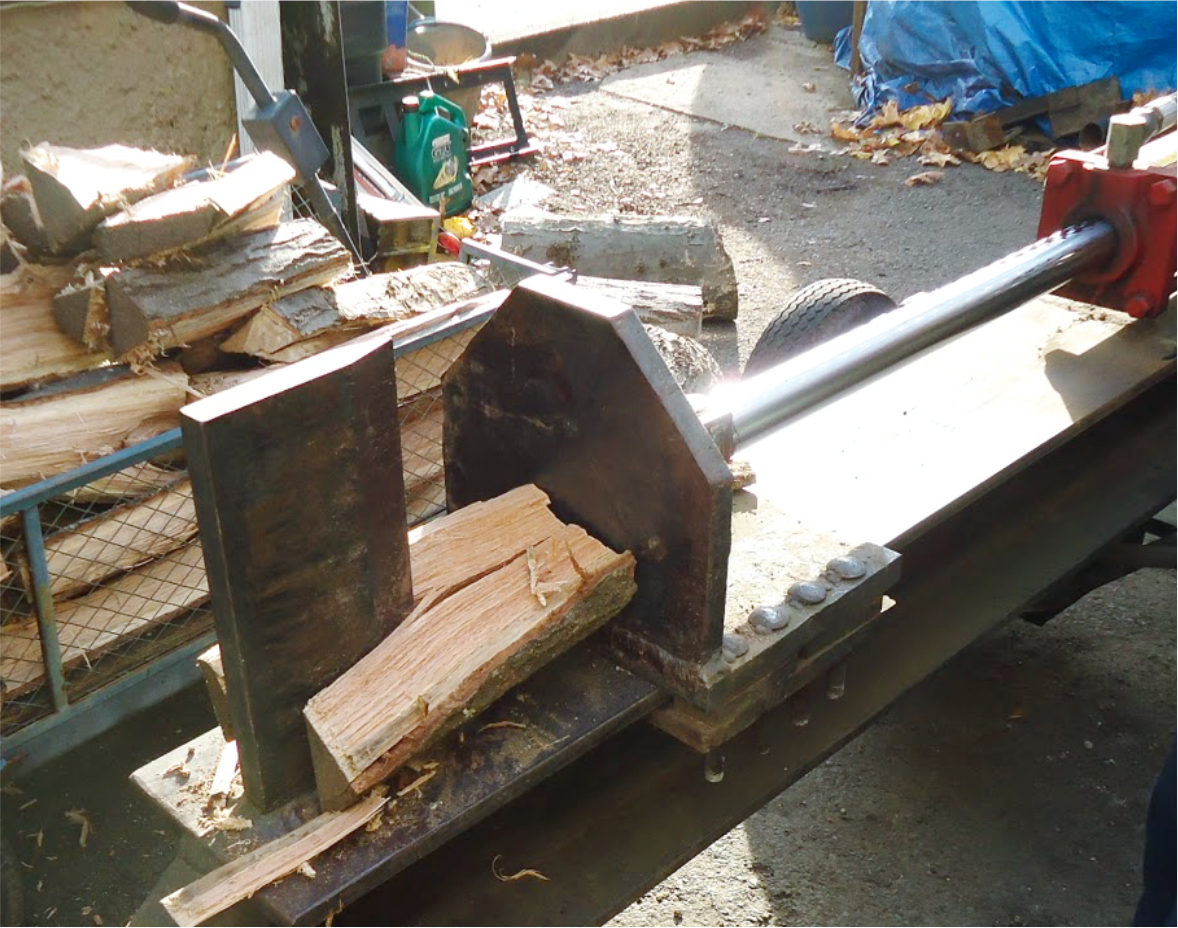 Image of a hydraulic ram splitting a piece of wood.