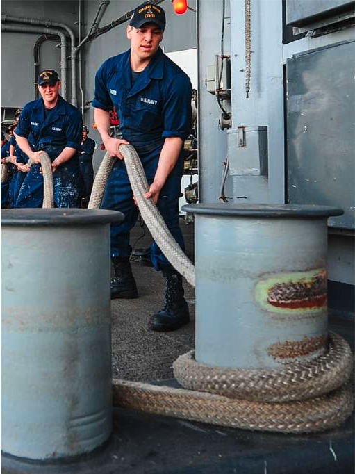 US Navy sailors handling a mooring line.